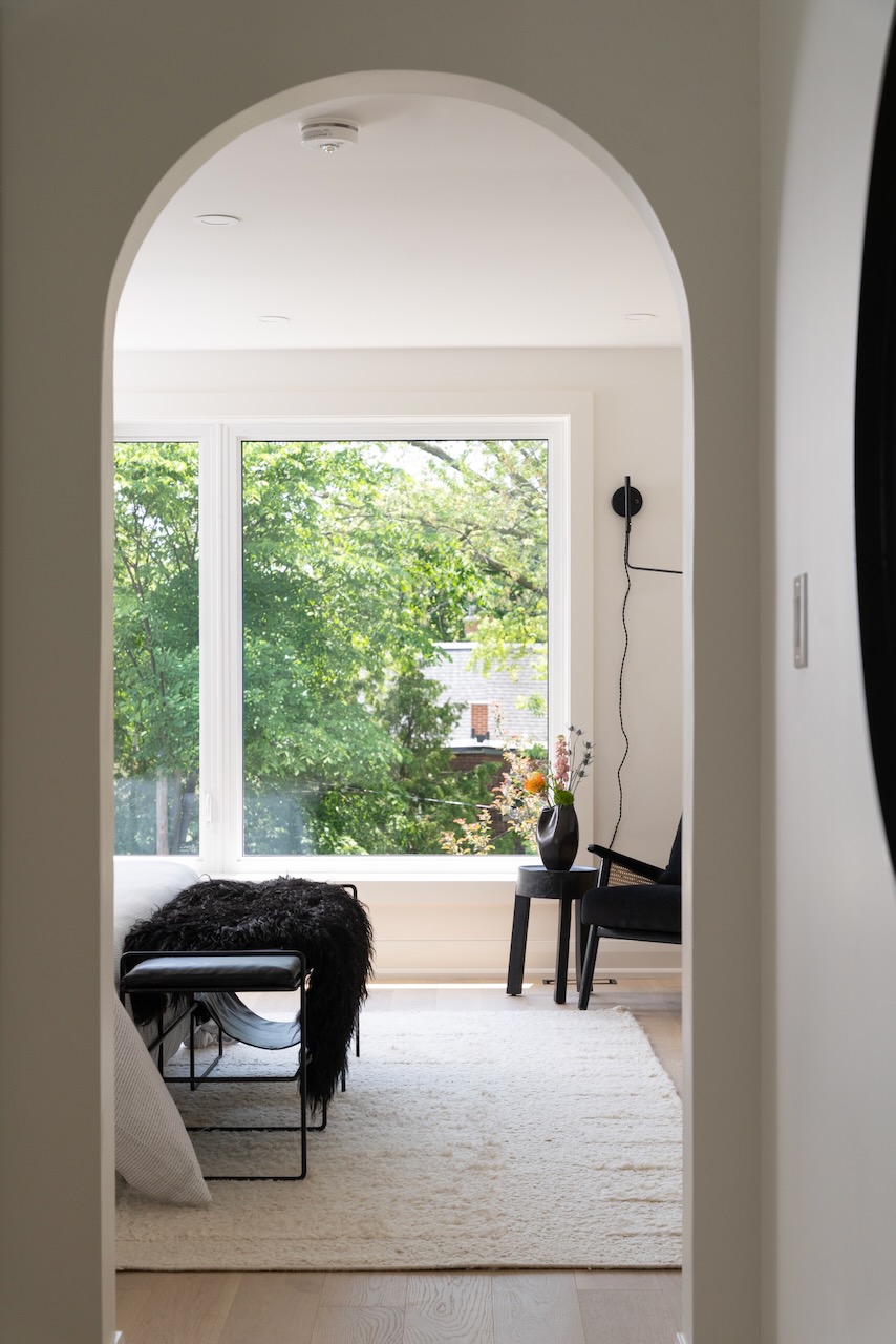 An arched opening framing a completed, light-filled bedroom